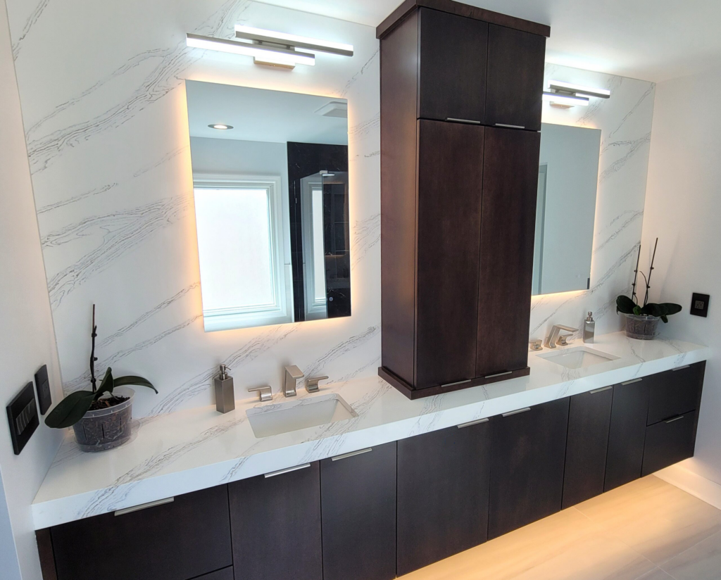Contemporary floating bathroom vanity with dark wood cabinetry, white marble countertop, backlit mirrors, and a tall storage tower.